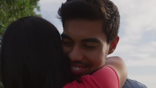 Young Man Embraces Woman in Gentle Hug