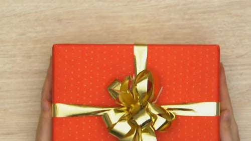Red Gift with Gold Bow Placed Down
