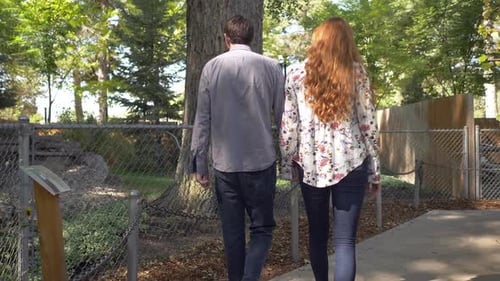 Couple Walking Hand in Hand in Urban Park