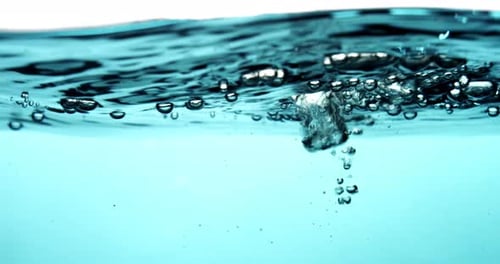 Bubbles rising in crystal clear water close-up