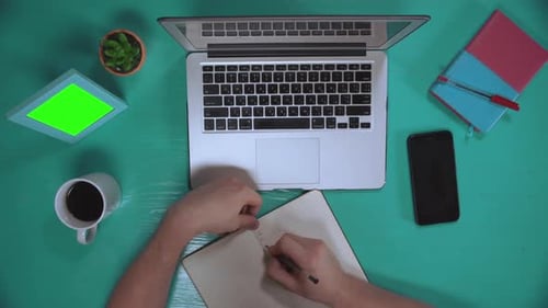 Overhead Office Scene With Writing and Laptop