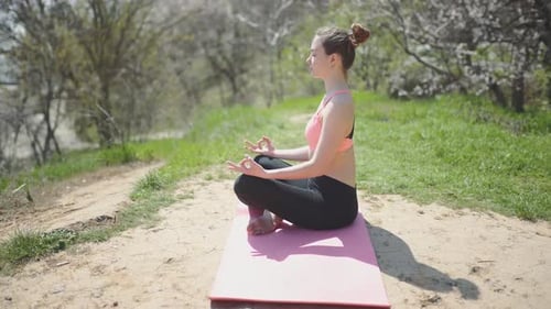 Young Beautiful Woman Practicing Yoga on the Beach at Sunny Day
