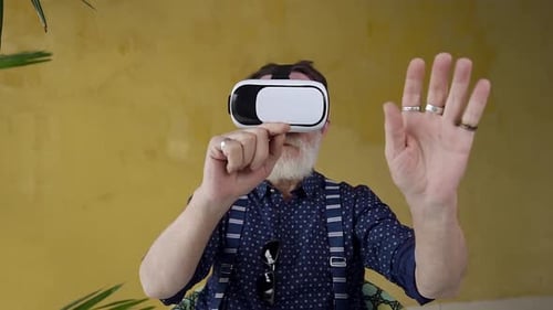 Senior Man Uses Virtual Reality Headset Indoors