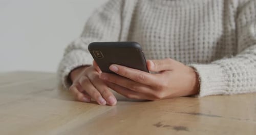 Woman Using Mobile Phone at Table Close Up