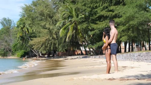 Romantic Young Couple Hugging in the Peaceful Beach on a Sunny Day
