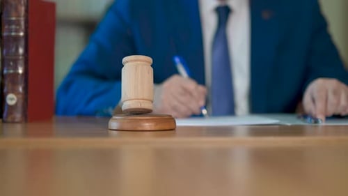 Wood Gavel on Desk with Legal Paperwork