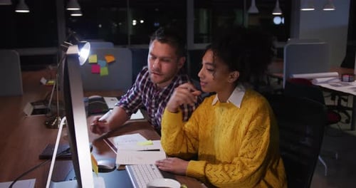 Young office executives discussing over computer in a modern office