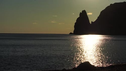 Sunset Over Sea Landscape with Yachts and Rocky Coastline