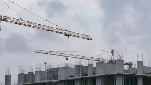 Hochbau. Turmdrehkran auf einer Baustelle. Bauherren arbeiten. Zeitraffer