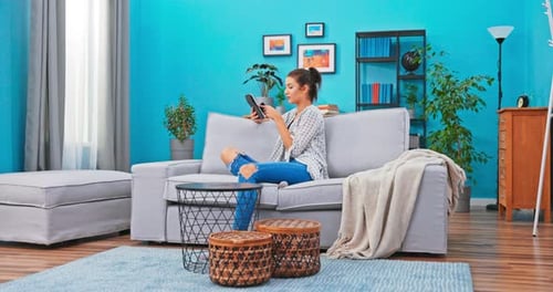 Young Woman Shopping Online at Home on Couch