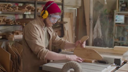 Woodworker Using Table Saw in Workshop