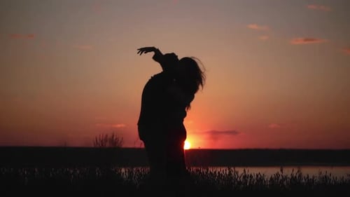 Couple Embraces at Sunset by the Lake
