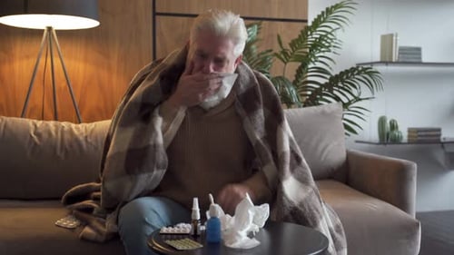 Man with Cold Coughing Indoors at Home