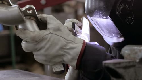 Verfahren zum Schweißen. Arbeiter, der Schweißarbeiten erledigt. Ein Mann im Helm beim Argonschweißen von Teilen