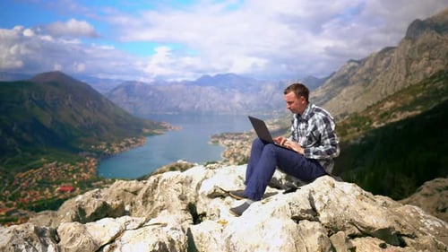 Man Working in Laptop on Mountain Top