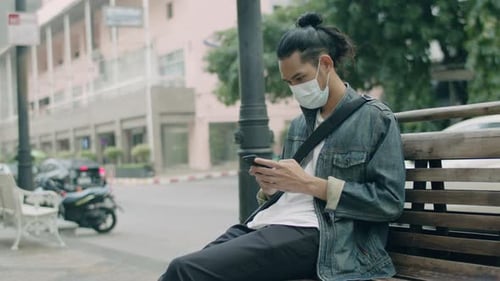 Young Adult on Phone Wearing Mask in City