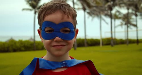 Smiling Child Wearing Mask and Cape Outdoors