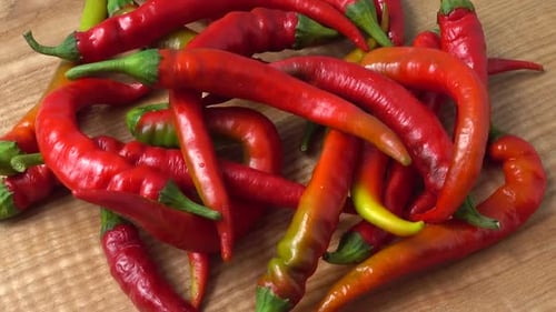 Red Chili Peppers Pile on Wooden Cutting Board