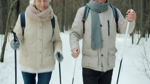 Happy Senior Family Talking During Nordic Ski Walk in Park on Winter Day