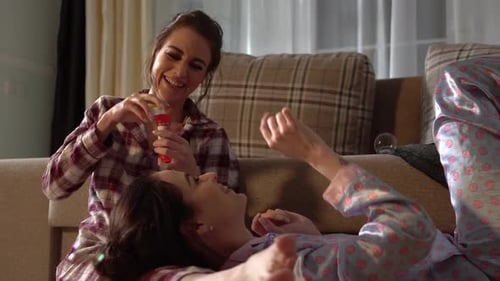 Twins Sisters Having Fun Blowing Bubbles Wearing Pretty Pajamas