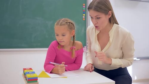 Préparation scolaire, une enseignante aide une fille apprenante à acquérir des connaissances à l'aide de figurines en plastique à