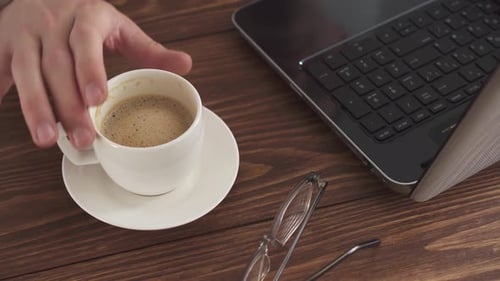 A Man Works At Home Using A Laptop Computer On A Wooden Table. Portrait Of A Business Man Working