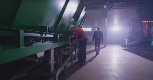 Male Mechanic Checking Conveyor Belt on Factory