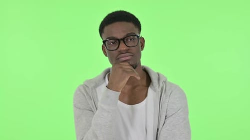 Pensive African Man Thinking and Getting Idea on Green Background