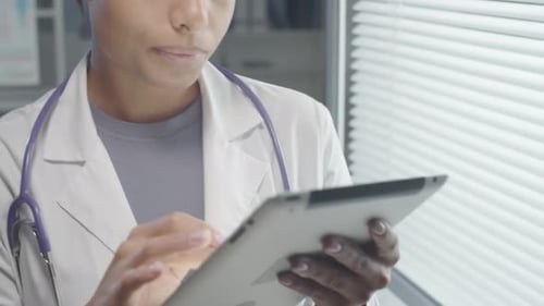 Doctor Using Tablet in Hospital Office