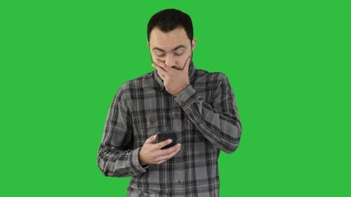 Young Adult Using a Smartphone on Green Screen