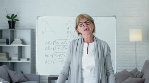 Woman Explaining Math in Bright Room with Whiteboard