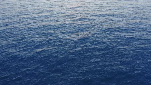 Luftaufnahme der blauen Meeresoberfläche mit Muster Ripple-Wellen bei Sonnenuntergang