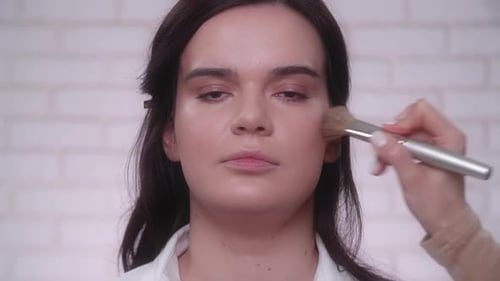 Makeup Artist Applies Cosmetics to Young Woman