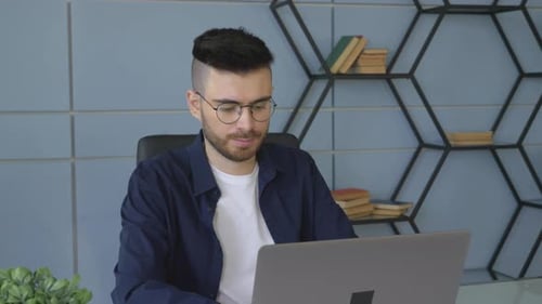 Man Working on Laptop in Modern Office
