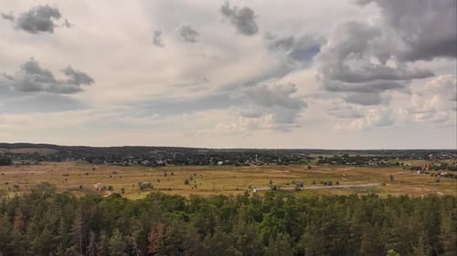 Hyperlapse Drohnen-Blick über grünen Wald mit sich bewegenden Wolken am blauen Himmel
