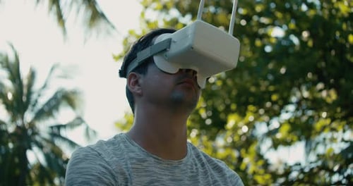 A Man in a Virtual Reality Helmet is Studying a Virtual Game