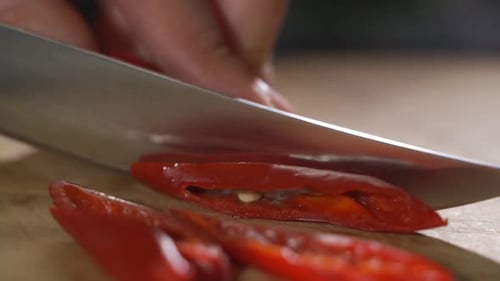 Knife Cutting Red Chilli Pepper on Wood