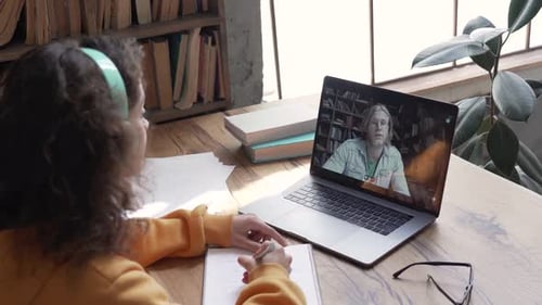 Hispanic Teen Girl School Student Distance Learn with Online Teacher on Laptop