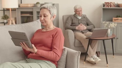 Senior Couple Relaxing At Home With Technology