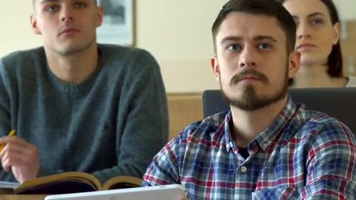 Un étudiant de sexe masculin utilise une tablette numérique dans la salle de conférence