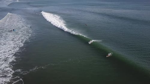 Aerial View of Surfers Catching Waves