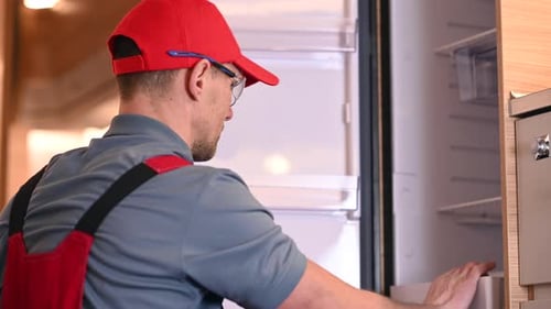 Man Removing Items from Refrigerator in RV Kitchen