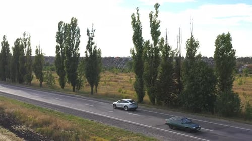 Aerial View of Electric Car Driving on Countryside Road. New Modern Vehicle Riding Fast Along