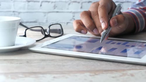 Man's Hand Working on Digital Tablet at Office Desk, Using Self Created Chart