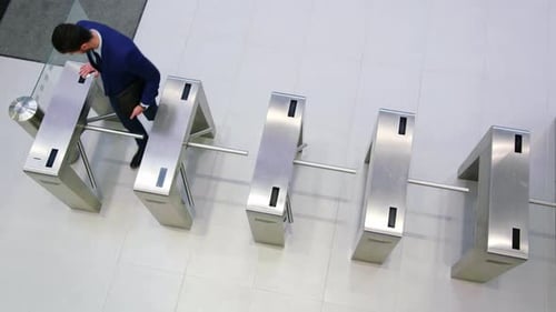Businesspeople scanning their cards at turnstile gate