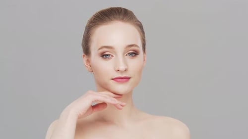 Studio portrait of young, beautiful and natural woman over grey background.