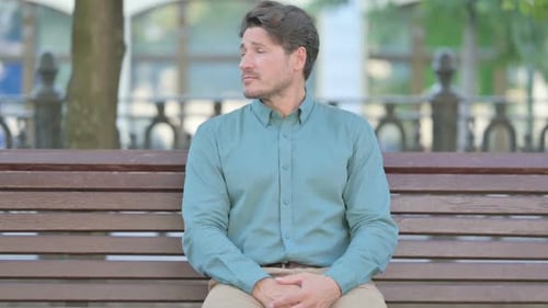 Middle Aged Man Sitting Outdoor and Waiting