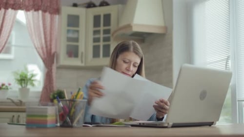 Woman Working at Laptop in Bright Kitchen