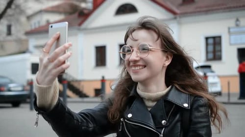 Happy Woman Video Calling on Phone Outdoors