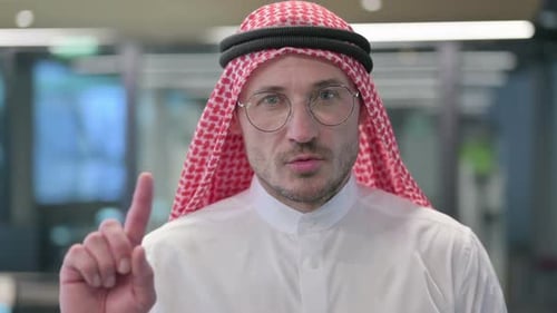 Man with Traditional Headdress Raises Finger